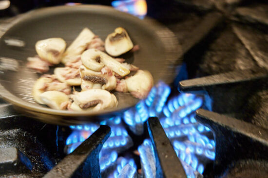 Frying mushrooms over a gas grill